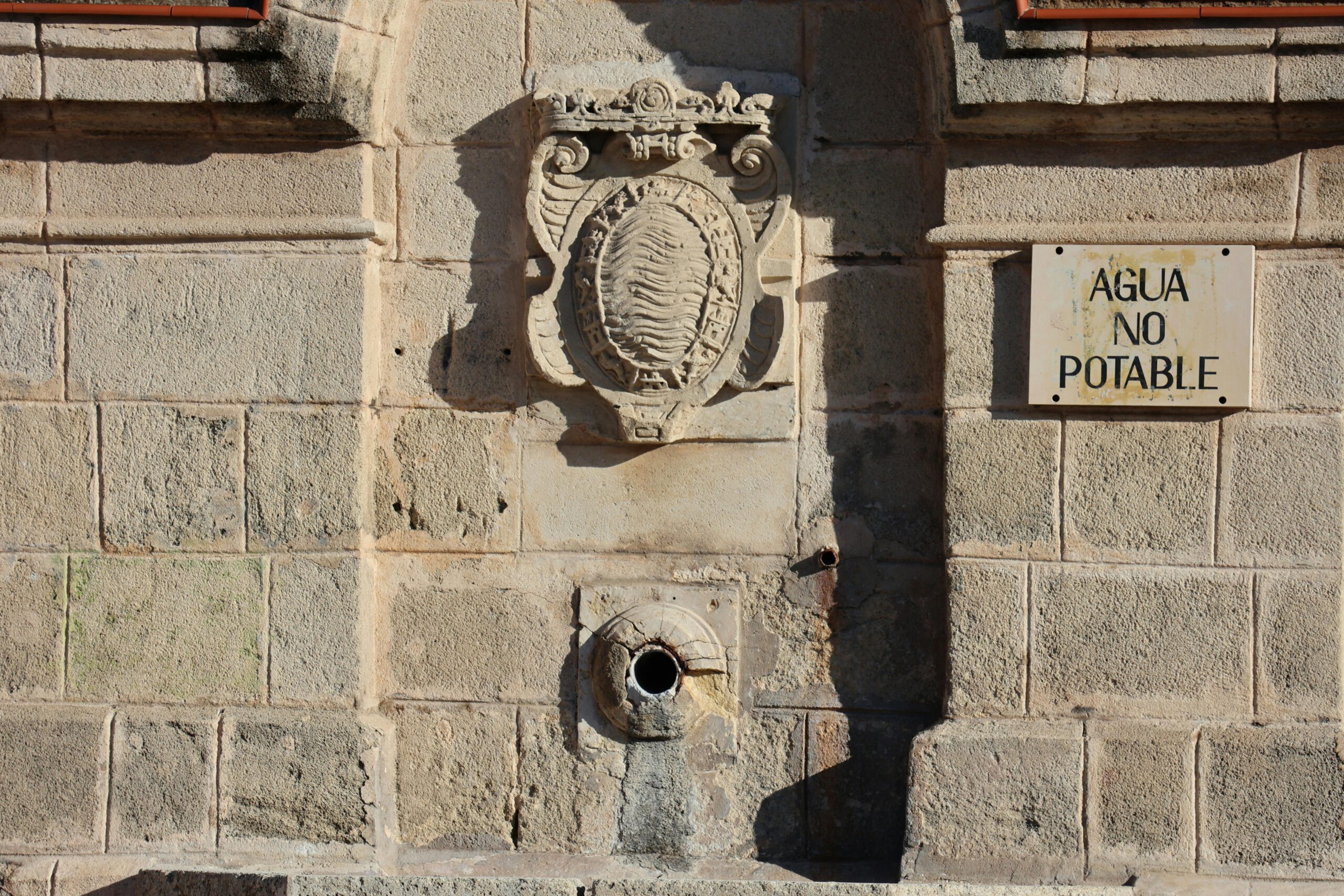 Alter Steinbrunnen in Jerez de la Frontera mit Hinweisschild „Kein Trinkwasser“.