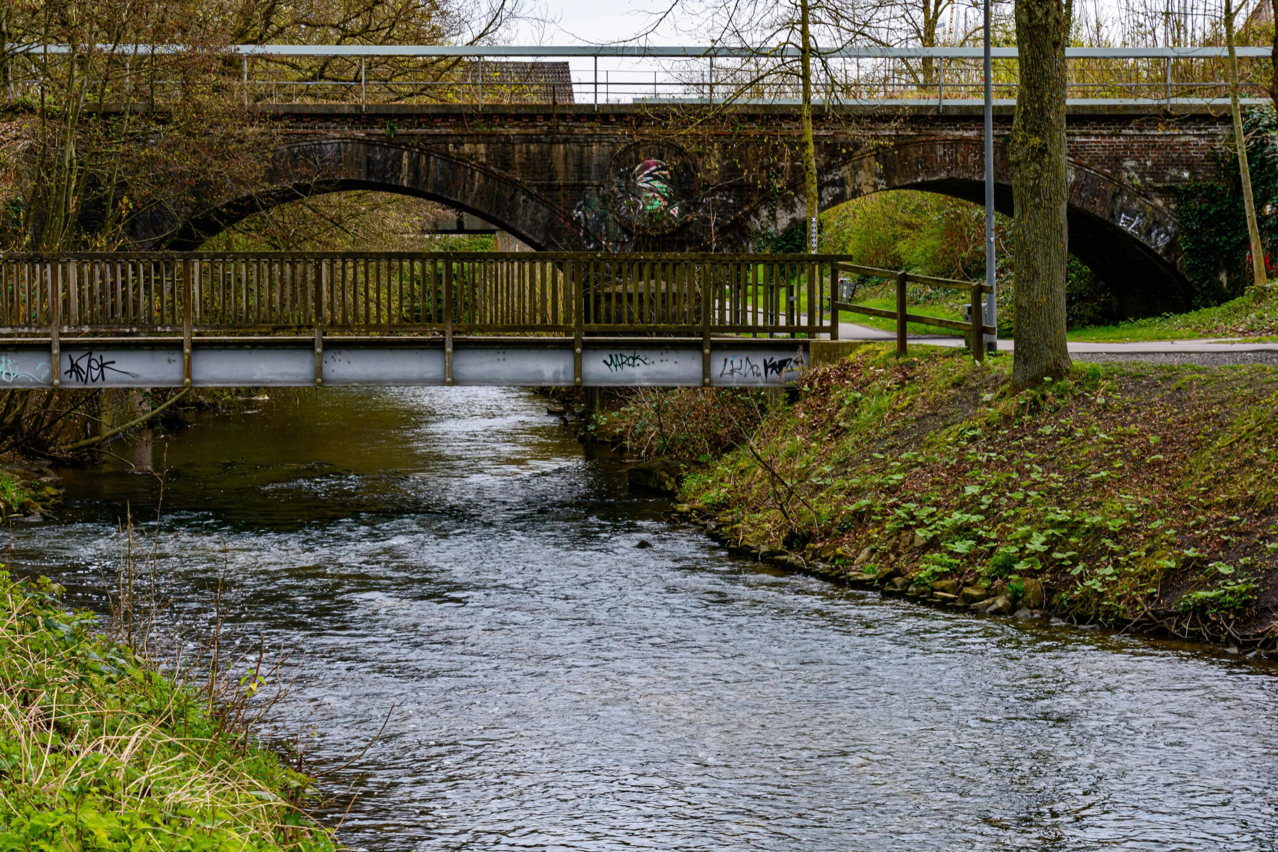 Eine malerische Flusslandschaft mit alten und neuen Brücken in Coesfeld, Deutschland.