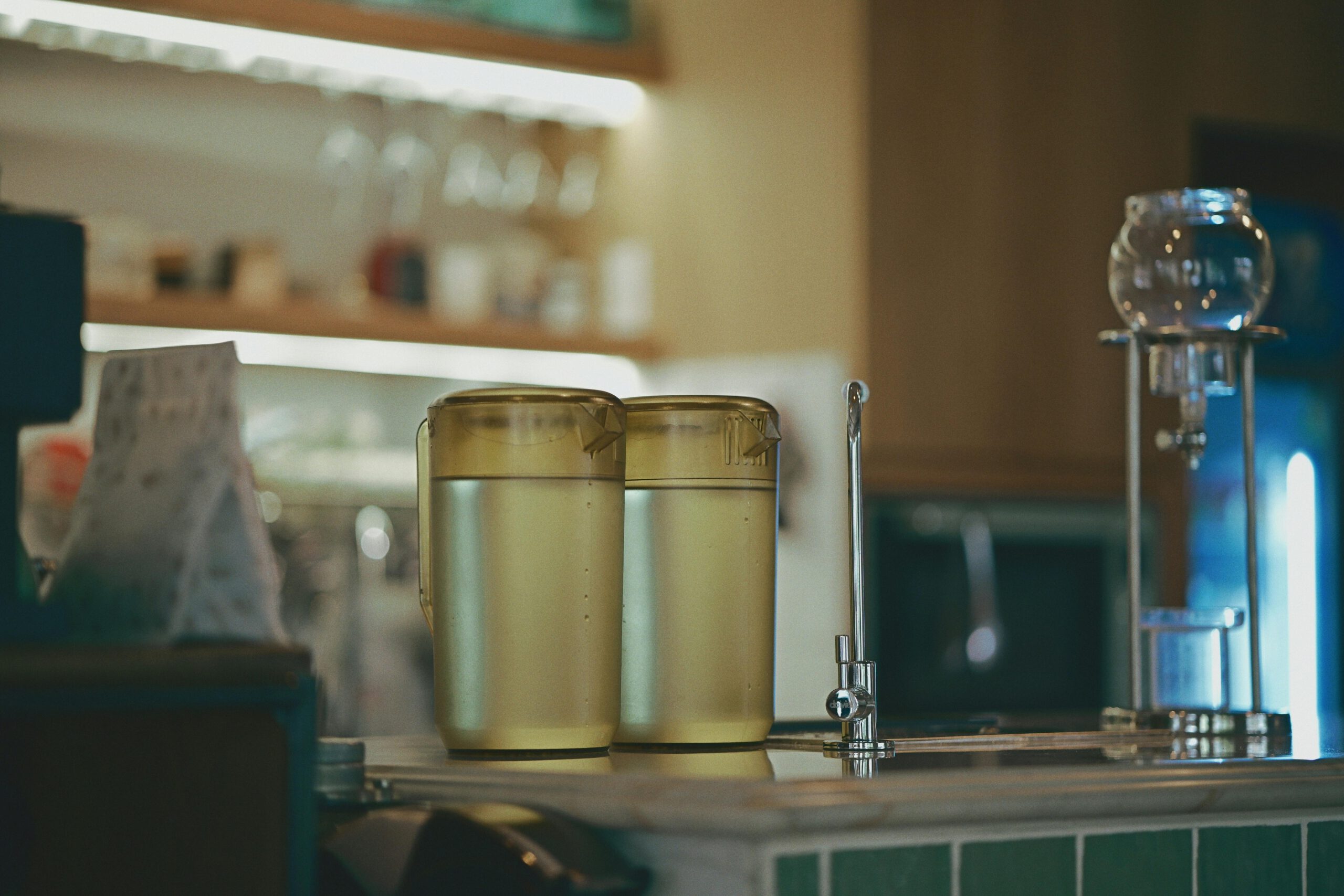 Ein gemütliches Café-Interieur mit Brühgerät und zwei Wasserkrügen auf der Theke.